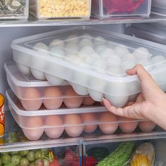 a refrigerator filled with lots of food and plastic containers full of eggs, carrots, celery