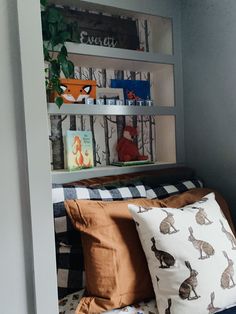 a bed with two pillows and some bookshelves in the back ground next to each other