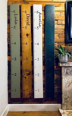 a wooden wall mounted to the side of a building with rulers on it's sides