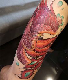 a colorful bird tattoo on the arm