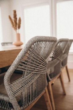 two wicker chairs sitting on top of a wooden table