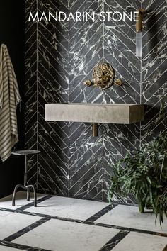 there is a black and white bathroom with marble tiles on the wall next to it