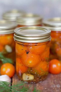 pickled cherry tomatoes in jars with text overlay reading pickled cherry tomatoes tomatoes with canning instructions