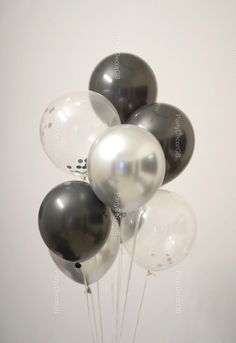 black and white balloons are in a vase