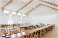 tables and chairs in a large room with chandeliers hanging from the ceiling above them