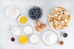 eggs, milk, and other ingredients are laid out on a white countertop to make an easy breakfast