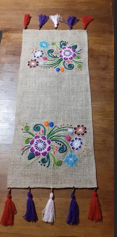 the table is decorated with colorful flowers and tassels on it's sides