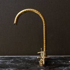 a golden faucet on a marble counter top