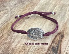 Saint medal bracelet,adjustable,unisex This bracelet comes on cording with 0.9" silver tone saint medal and sliding slipknot for an easy fit. 9.5″ (24cm)when fully opened.Choose your saint and we will make the bracelet just for you!❤️ lightweight and comfortable to wear. Perfect bracelet for everyday! Hand made in Medjugorje. A nice gift for a loved one or a statement of faith to wear yourself. For more similar items and different colors visit our store: https://www.etsy.com/shop/Thelightjewelry St. Rita, St Joan Of Arc, St Dymphna, Saint Joan Of Arc, Jeanne D'arc, Heart Of Mary, St Joan, St Anne, Joan Of Arc