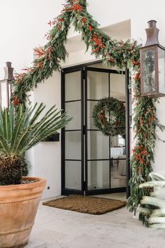 the front door is decorated with greenery and wreaths