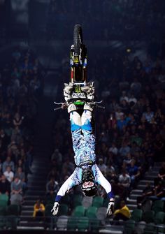 a person on a bike doing a trick in the air with his hands and feet