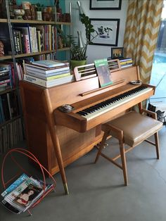 a piano sitting in front of a book shelf filled with books