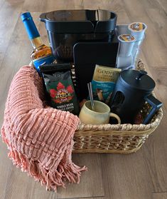 a wicker basket filled with coffee, tea and other items on a wooden floor