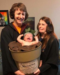 a man and woman holding a baby in a bucket