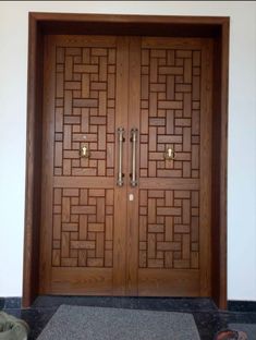 two wooden doors with decorative designs on the front and side panels, in an entry way