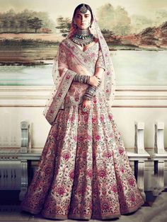 a woman in a pink and white bridal gown standing next to a large painting