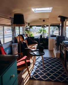 a living area with couches, tables and television in the back of a bus