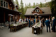 a group of people standing around tables in front of a house