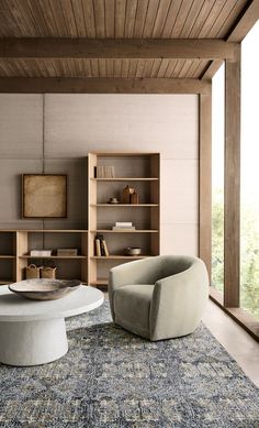 a living room with two chairs and a coffee table in the middle, on top of an area rug