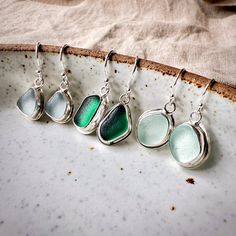 These handmade silver earrings are made with genuine Seaham sea glass from the North East of England in the UK. They come in a variety of colours, from delicate seafood blue to gorgeous teal green.  Size of sea glass: approx. 12-15 mm Drop length: approx. 25-28 mm The pieces of sea glass have been hand-selected and delicately arranged into matching pairs of shape and colour before being bezel set in recycled 925 sterling silver and attached to simple sterling silver ear wires. These earrings mak Silver Sea Glass Drop Earrings, Silver Sea Glass Dangle Earrings, Handmade Silver Sea Glass Earrings, Beach Earrings In Silver With Recycled Glass, Silver Sea Glass Earrings For Gift, Beach Silver Earrings With Recycled Glass, Handmade Silver Earrings With Sea Glass, Silver Sea Glass Earrings For Beach, Silver Recycled Glass Beach Earrings