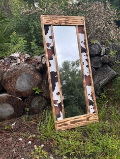 a mirror sitting on top of a pile of logs