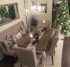 a dining room table with chairs and a christmas tree in the corner next to it