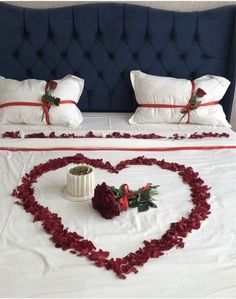 a heart shaped bed with roses on it and a vase in the shape of a heart