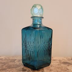 a blue glass bottle sitting on top of a table