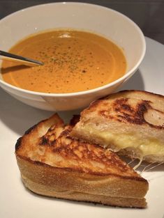 grilled cheese sandwich with soup in bowl on white plate