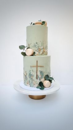 a three tiered cake decorated with flowers and greenery sits on a white plate