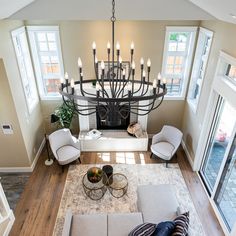 a living room filled with furniture and a chandelier in the middle of it