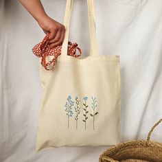 "Beautiful and elegant handpainted cottagecore blue tote bag. It's an ideal shopping bag, for your books and even a nice fashion bag for the whole year . In addition, it is very comfortable because of its long handles and many things fit :) 38 cm x 41 cm (14,96\" x 16,14\") The tote bags hold approximately 22.05 lbs (10 kg). I tell you how I painted it: First, I wash the cloth bag. This is how I get the final size of the bag (you will not be surprised when washing it because it already has its f Easy Tote Bag Design, Painting On Tote Bags Aesthetic, Tote Bag Painting Ideas Flowers, Tote Bag Design Embroidery, Cute Tote Bag Design Paint, Flower Tote Bag Design, Tote Bag Diy Paint, Tote Bag Inspo Paint, Tote Bag Flower Design