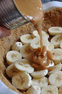 a person pouring peanut butter on bananas in a bowl