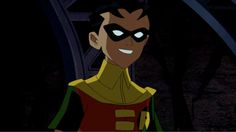 the animated character is smiling and wearing a green caper outfit with yellow accents on his face