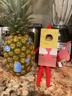 a pineapple sitting on top of a counter next to a cut out of a person