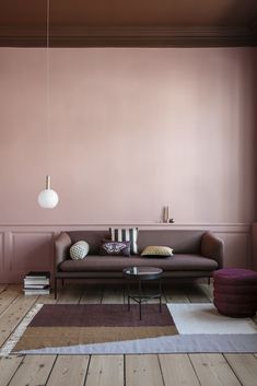 a living room with pink walls and wooden floors