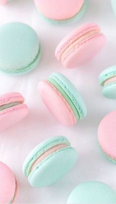 several macaroons are arranged on a white surface with pink and blue frosting