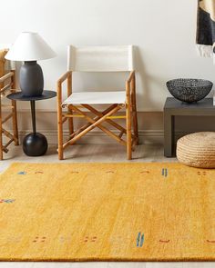 a living room with two chairs and a rug on the floor