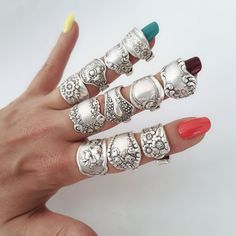 a woman's hand with five rings on it and two manies in the middle