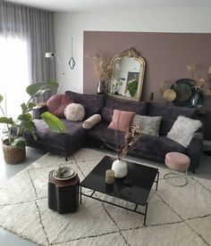 a living room filled with lots of furniture next to a large mirror on the wall