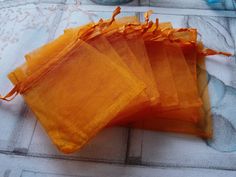 four orange bags sitting on top of a white towel covered floor next to a blue vase