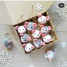 a box filled with knitted mice next to snowflakes