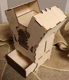 a wooden model of a house sitting on top of burlocked cloths