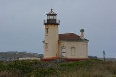 a light house sitting on top of a lush green hillside