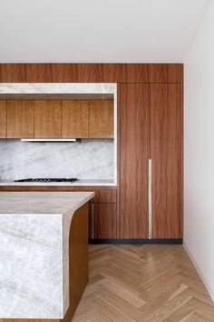 A contemporary kitchen with a large island, wood cabinets, and LED lighting. Timber Ceiling, Stone Masonry, Contemporary Apartment, Architectural Practice, Modern Buildings