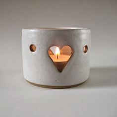 a white candle holder with a heart on it