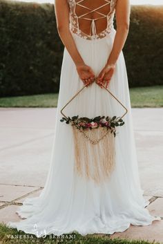 a woman in a white dress holding a flower crown