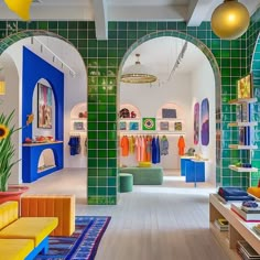 the inside of a clothing store with green and blue tiles on the walls, colorful furniture and decorations