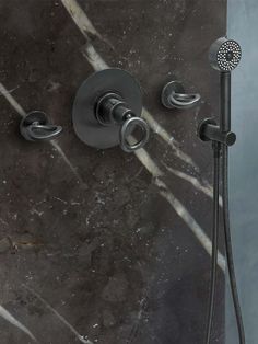 an image of a shower head and handset with marbled wall in the background