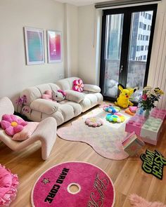 a living room filled with lots of furniture and pink rugs on top of hard wood flooring